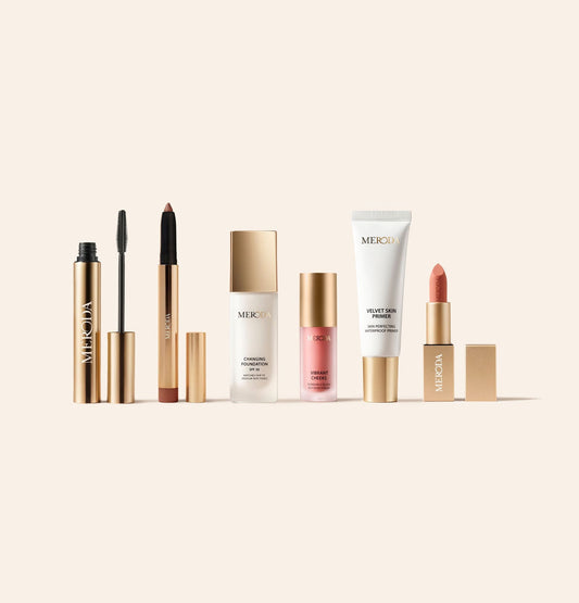 Endless Summer Bundle featuring Gilded Lashes Mascara, Eye Perfecting Shimmer Stick, Changing Foundation, Vibrant Cheek Blush, Velvet Skin Primer and Velvet Dream Lipstick on a beige background