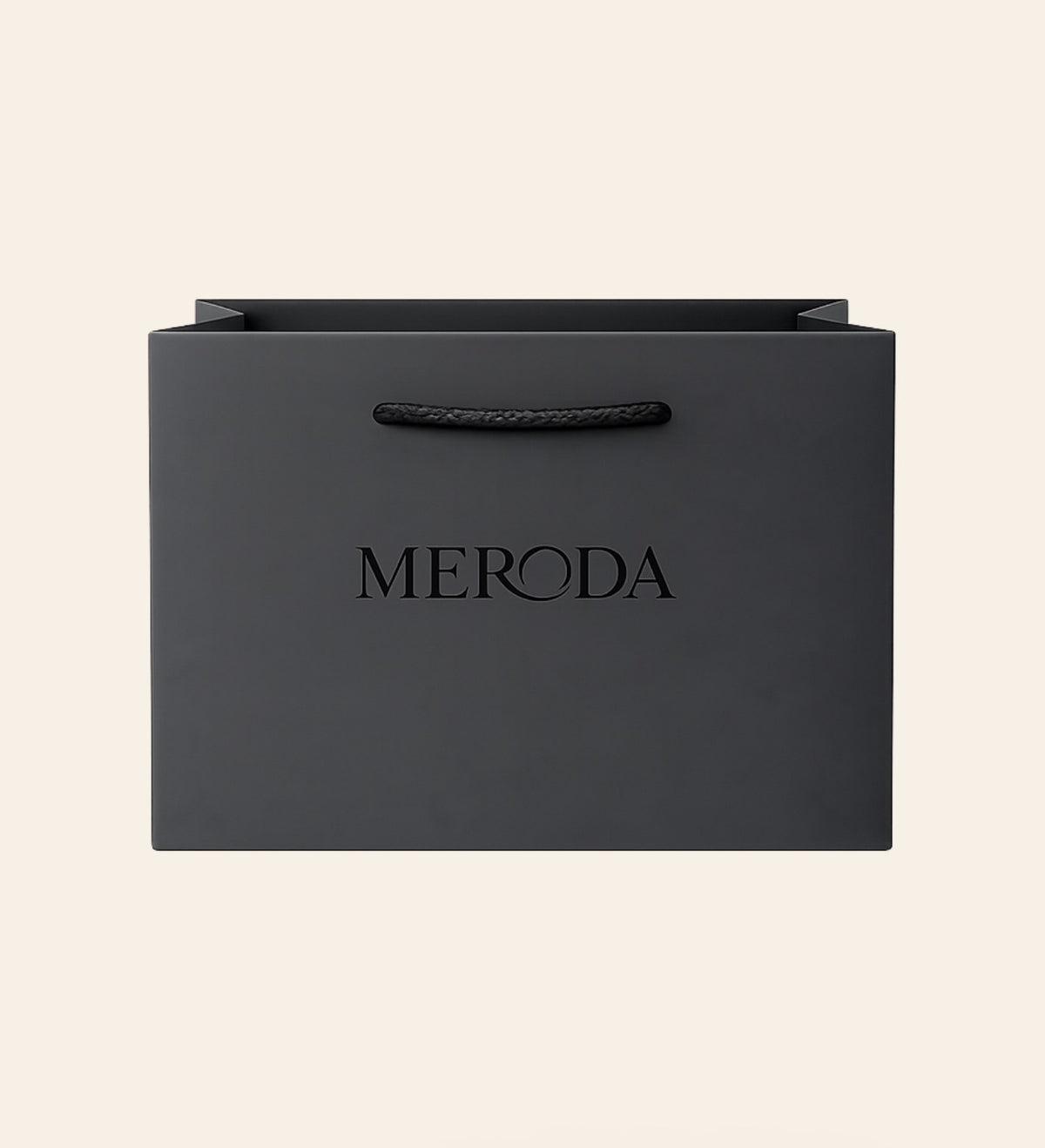Gift Bag in matte black featuring a woven rope handle and embossed Meroda logo on a cream background.
