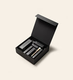Matte black Gift Box with a magnetic closure filled with Meroda Cosmetics products and a gold makeup brush.