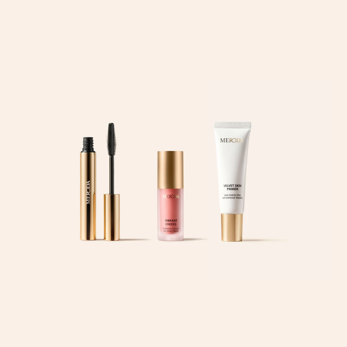 Meroda Minis set featuring Gilded Lashes Mascara, Vibrant Cheeks Liquid Blush and Velvet Skin Primer in gold packaging.