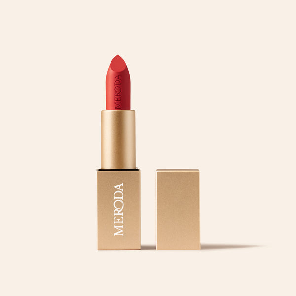 Meroda Velvet Dream Lipstick in Luscious Red with open gold packaging on a light background.