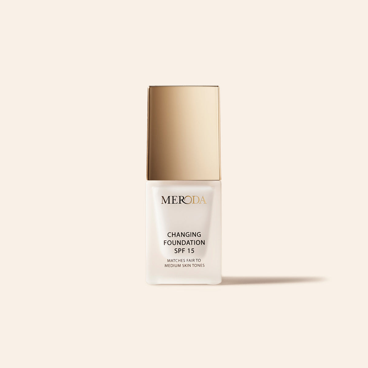 Meroda Mini Changing Foundation SPF 15 in a white bottle and gold cap for fair to medium skin tones.