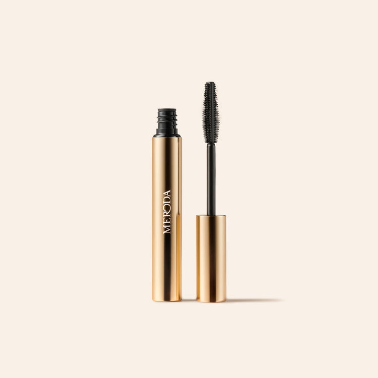 Meroda Cosmetics Mini Mascara featuring an open gold tube and wand applicator for length and volume