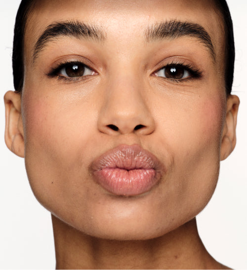 Meroda Cosmetics Hydrating Lip Tint in Honey Beige on a model, providing a sheer satin finish and naturally fuller lips.