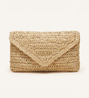 Summer Travel Clutch in natural woven paper straw with a triangular flap and central Meroda logo plate.