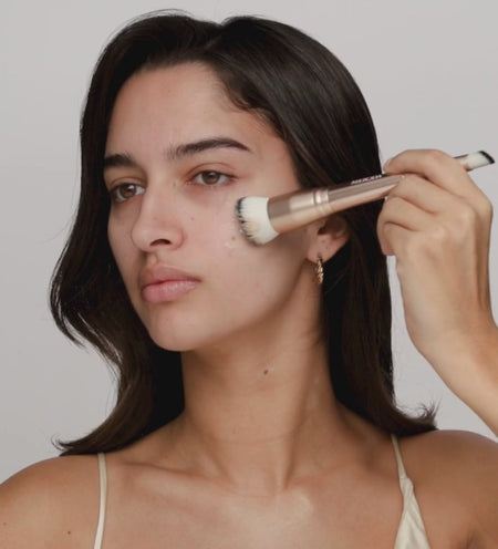 Applying Changing Foundation with the 2-in-1 Build & Conceal Brush for a seamless, shade-adapted finish.